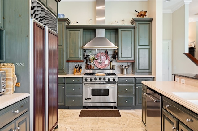 kitchen with wall chimney exhaust hood, ornamental molding, high quality appliances, and backsplash