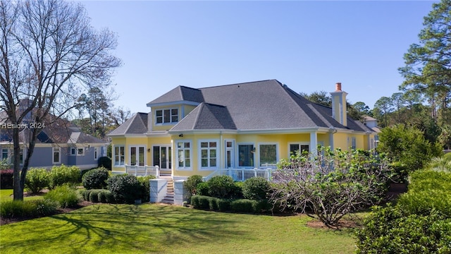 rear view of property with a lawn