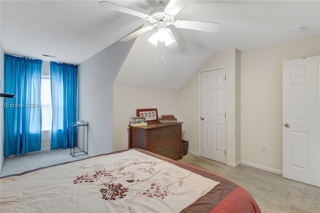 bedroom with vaulted ceiling, light colored carpet, and ceiling fan