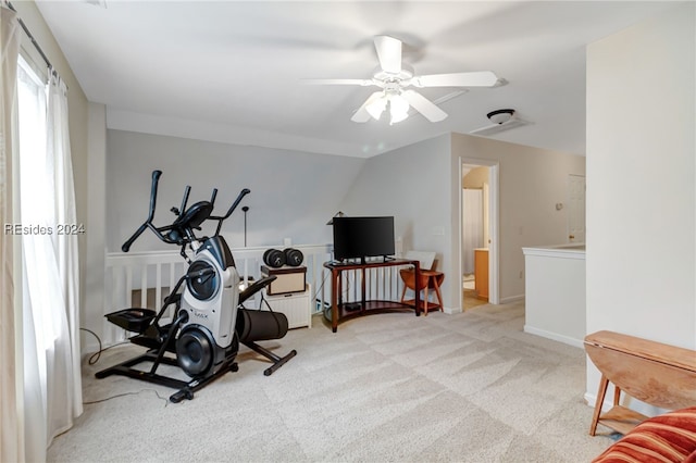 workout room featuring lofted ceiling and light colored carpet