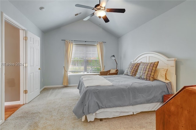 bedroom featuring vaulted ceiling, light colored carpet, and ceiling fan