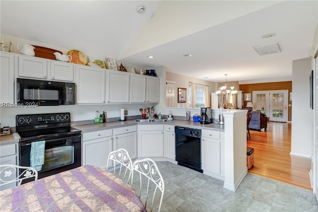 kitchen featuring white cabinetry, decorative light fixtures, kitchen peninsula, and black appliances