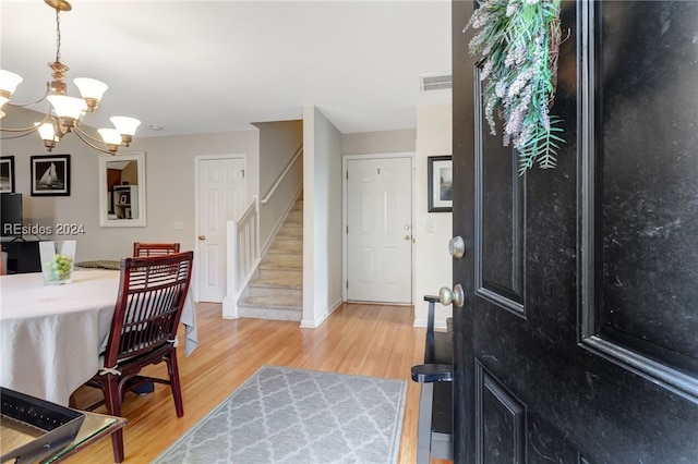 entrance foyer with wood-type flooring and an inviting chandelier