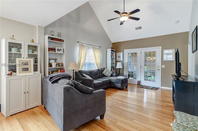 living room featuring light hardwood / wood-style flooring, high vaulted ceiling, and ceiling fan