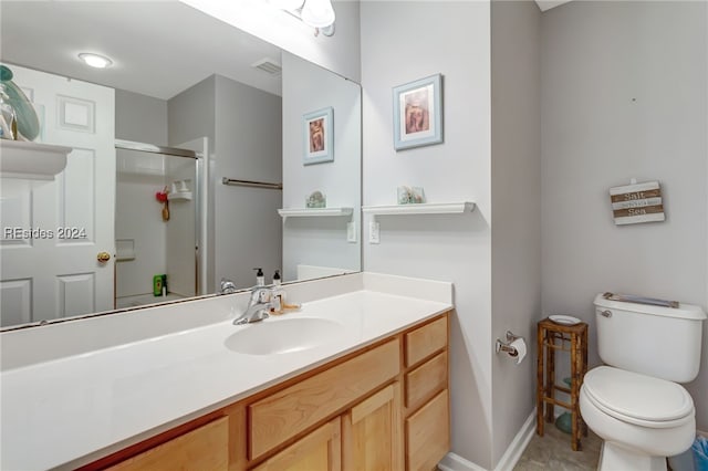 bathroom featuring vanity, toilet, and walk in shower