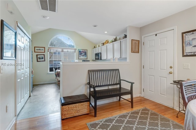 sitting room featuring vaulted ceiling and light wood-type flooring