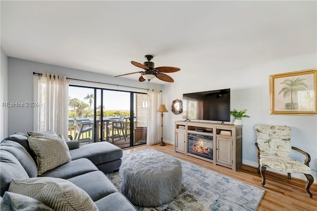 living room featuring ceiling fan and light hardwood / wood-style flooring