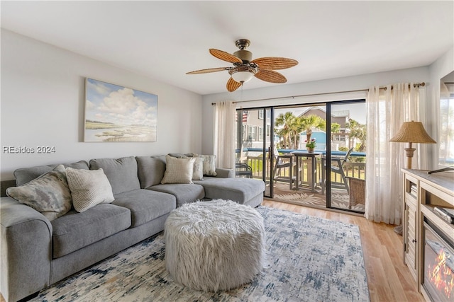 living room featuring ceiling fan, light hardwood / wood-style floors, and a wealth of natural light