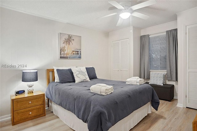 bedroom with ceiling fan, light hardwood / wood-style floors, and a textured ceiling