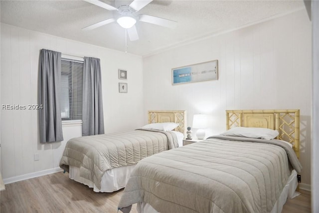 bedroom with light wood-type flooring, a textured ceiling, and ceiling fan