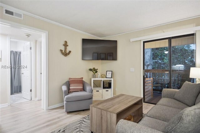 living room featuring crown molding and light hardwood / wood-style flooring