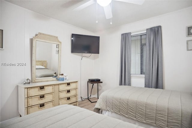 bedroom with ornamental molding, ceiling fan, and light hardwood / wood-style floors