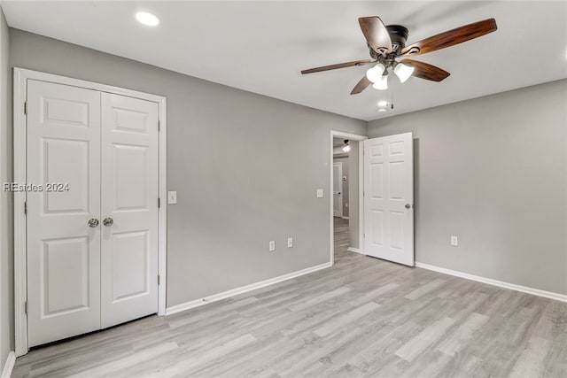 unfurnished bedroom with light wood-type flooring, ceiling fan, and a closet