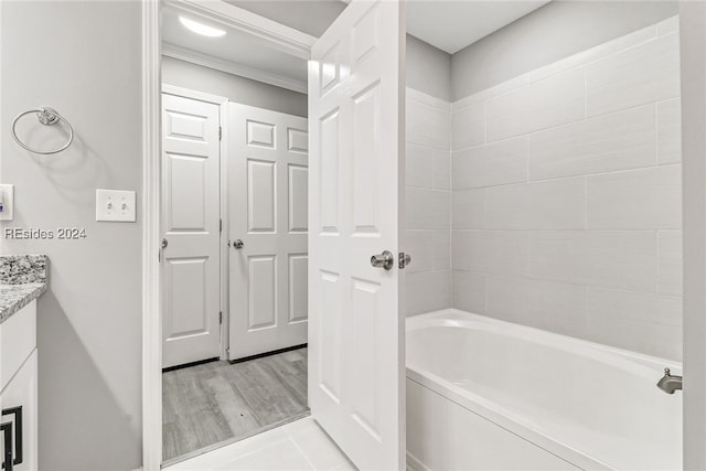 bathroom featuring crown molding, vanity, and shower / washtub combination