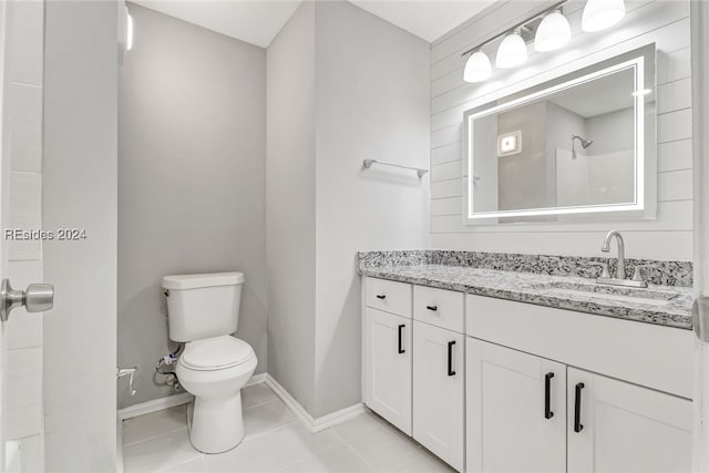 bathroom with tile patterned flooring, vanity, walk in shower, and toilet