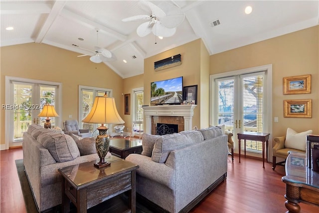 living room with a tile fireplace, dark wood-type flooring, and vaulted ceiling with beams