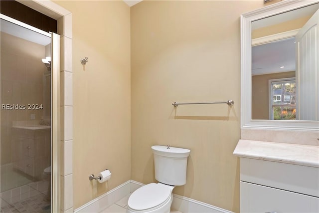 bathroom with vanity, a shower with shower door, and toilet