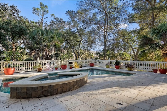 view of swimming pool featuring a patio area and an in ground hot tub