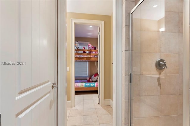 bathroom with a shower with shower door and tile patterned floors