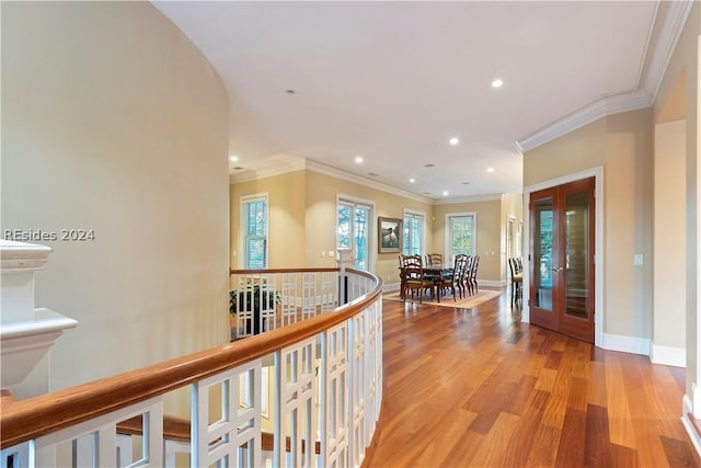 hall with crown molding, french doors, and light wood-type flooring