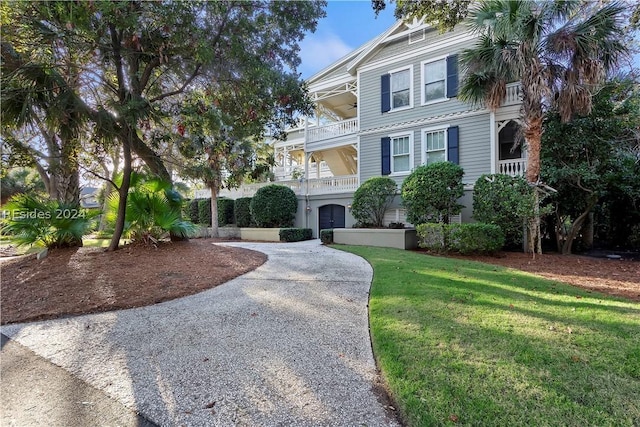 view of front of property with a front yard and a balcony