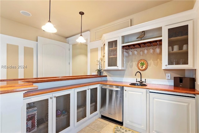 kitchen featuring light tile patterned flooring, sink, white cabinetry, stainless steel dishwasher, and pendant lighting