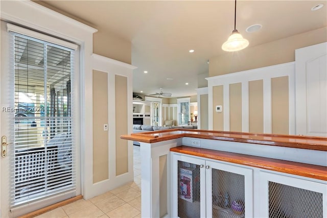 kitchen featuring pendant lighting, wooden counters, ceiling fan, and light tile patterned floors