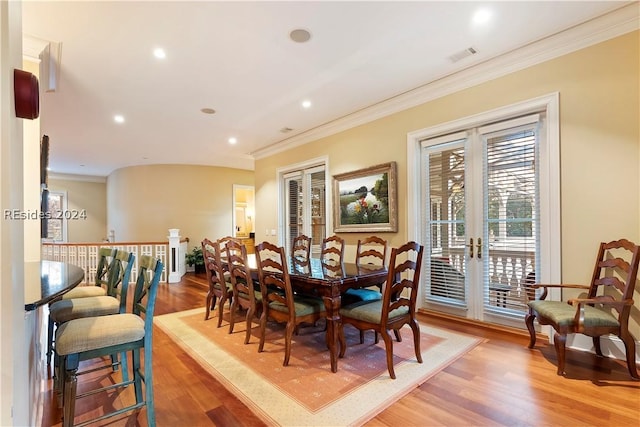 dining room featuring hardwood / wood-style floors, ornamental molding, and french doors