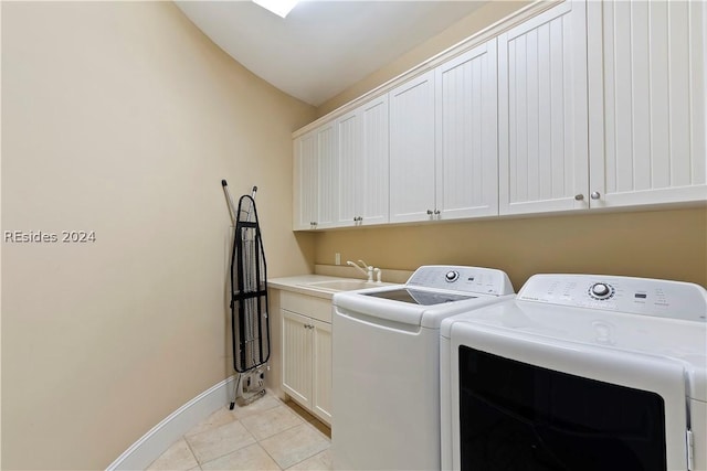 clothes washing area featuring light tile patterned flooring, cabinets, sink, and washing machine and dryer