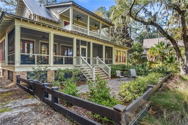 rear view of house featuring a sunroom and a patio area