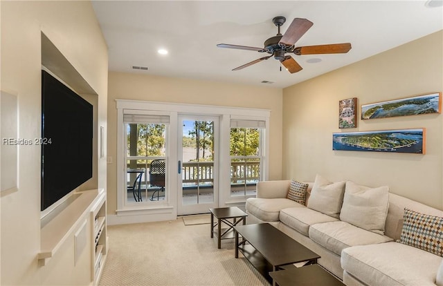 living room featuring light colored carpet and ceiling fan