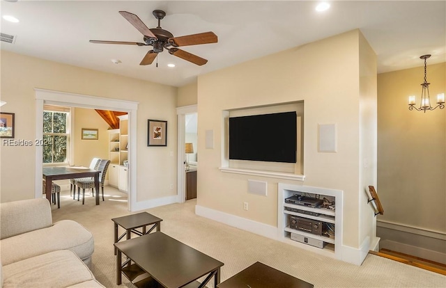 carpeted living room with ceiling fan with notable chandelier and built in features