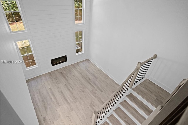 staircase with wood-type flooring and a fireplace