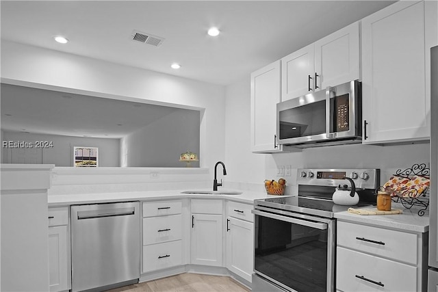 kitchen featuring stainless steel appliances, white cabinetry, and sink