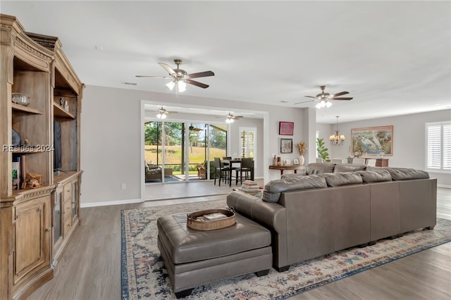 living room with a chandelier and light wood-type flooring