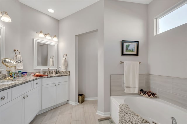 bathroom featuring vanity, tile patterned flooring, and a washtub