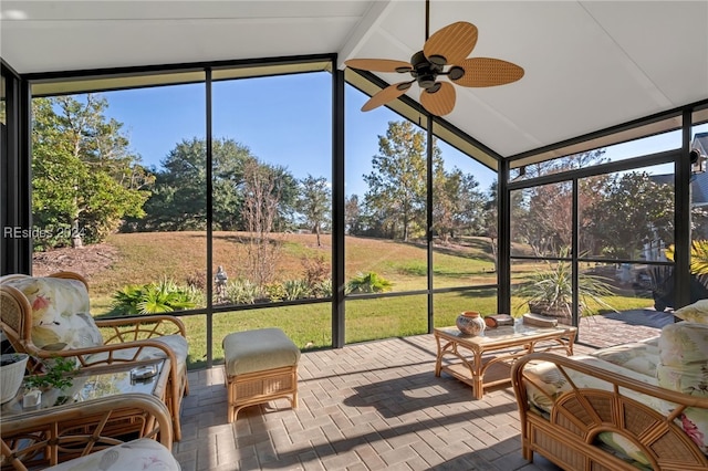 sunroom with ceiling fan, plenty of natural light, and vaulted ceiling