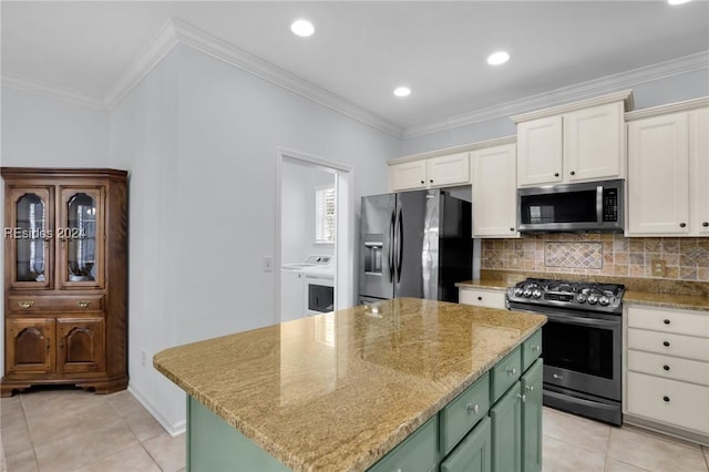 kitchen with crown molding, a kitchen island, green cabinetry, and appliances with stainless steel finishes