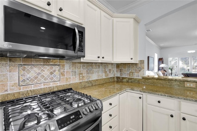 kitchen featuring white cabinetry, appliances with stainless steel finishes, stone countertops, and crown molding