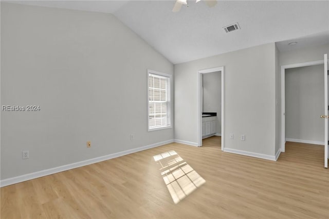 unfurnished bedroom with ceiling fan, ensuite bathroom, light hardwood / wood-style floors, and lofted ceiling