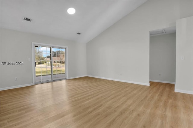 unfurnished room featuring lofted ceiling and light wood-type flooring