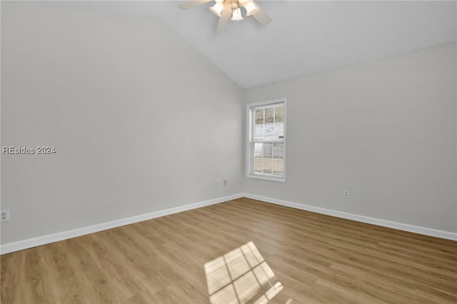 spare room with ceiling fan, vaulted ceiling, and light wood-type flooring