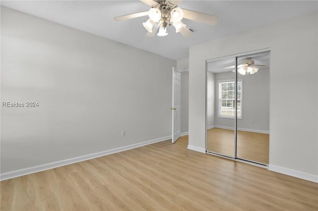 unfurnished bedroom featuring light hardwood / wood-style floors, ceiling fan, and a closet