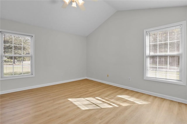 unfurnished room with vaulted ceiling, a healthy amount of sunlight, and light hardwood / wood-style flooring