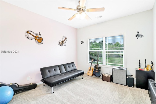 sitting room with ceiling fan and carpet