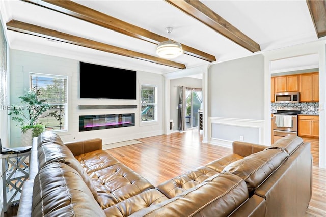 living room featuring beam ceiling and light hardwood / wood-style floors