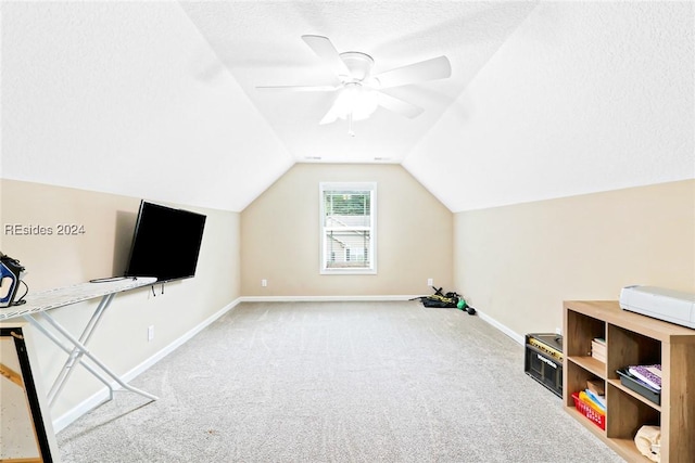 additional living space with ceiling fan, light colored carpet, vaulted ceiling, and a textured ceiling