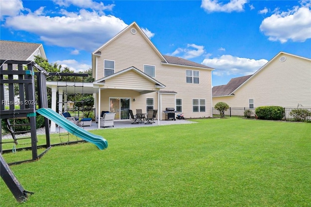 rear view of property featuring a yard, a patio area, and a playground