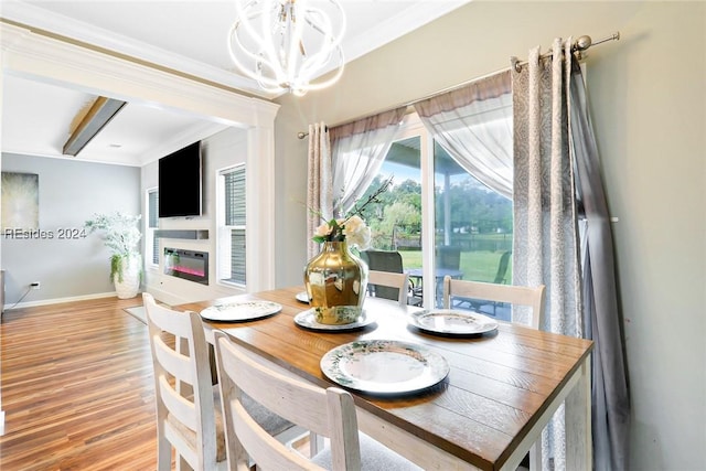 dining room featuring crown molding, a notable chandelier, and light hardwood / wood-style flooring