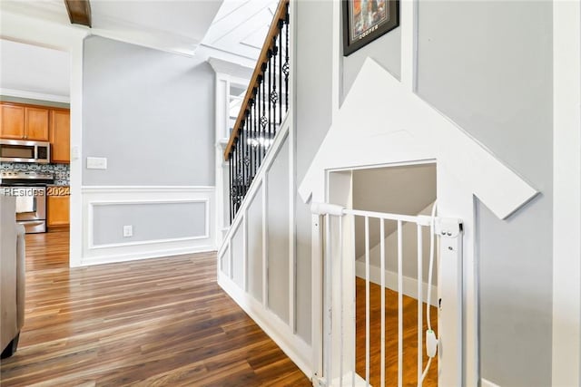 staircase featuring ornamental molding and hardwood / wood-style floors